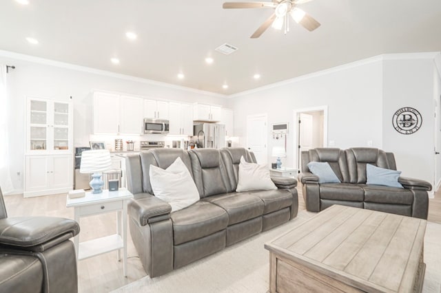 living area featuring light wood-type flooring, ornamental molding, visible vents, and ceiling fan