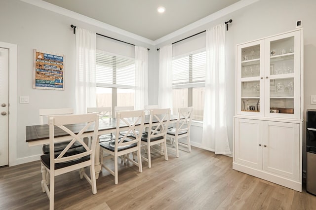 dining space with light wood-style flooring and baseboards