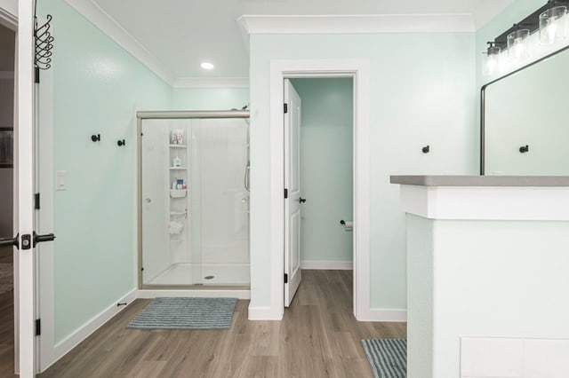 full bath with wood finished floors, baseboards, recessed lighting, ornamental molding, and a shower stall