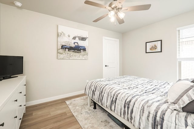 bedroom with a ceiling fan, light wood-style floors, and baseboards