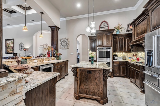 kitchen with crown molding, decorative backsplash, arched walkways, stainless steel appliances, and a sink