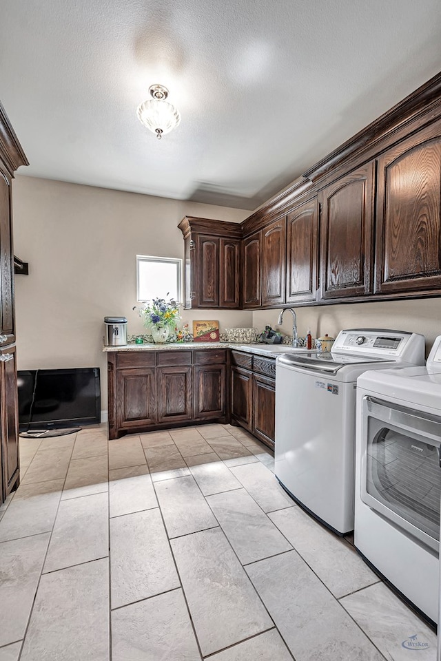 clothes washing area with light tile patterned floors, cabinet space, separate washer and dryer, a sink, and a textured ceiling