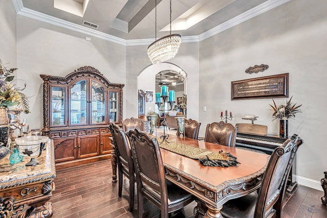 dining area with arched walkways, visible vents, wood finish floors, and an inviting chandelier