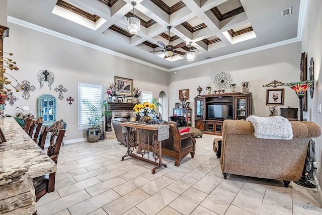 living area featuring visible vents, a ceiling fan, arched walkways, crown molding, and a towering ceiling