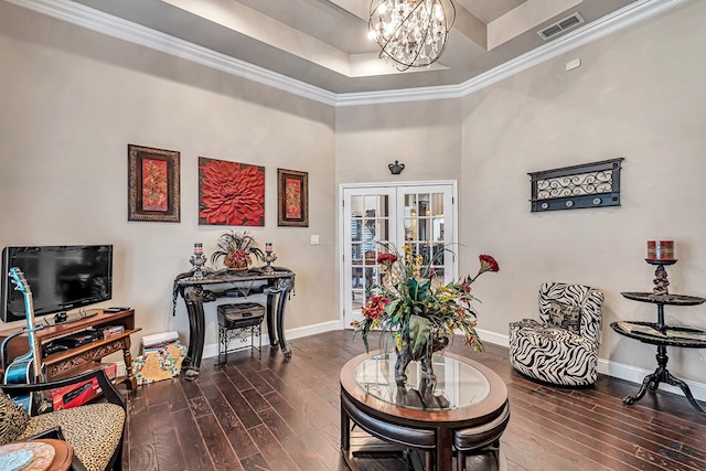 living area with an inviting chandelier, dark wood-style floors, visible vents, and baseboards