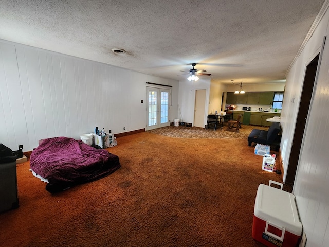 interior space featuring carpet flooring, ceiling fan, a textured ceiling, and french doors