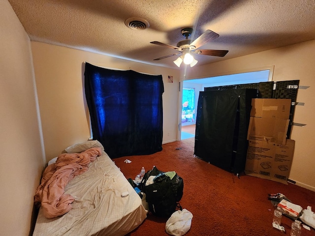 carpeted bedroom featuring ceiling fan and a textured ceiling