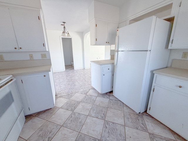 kitchen featuring white appliances, white cabinetry, light countertops, and arched walkways