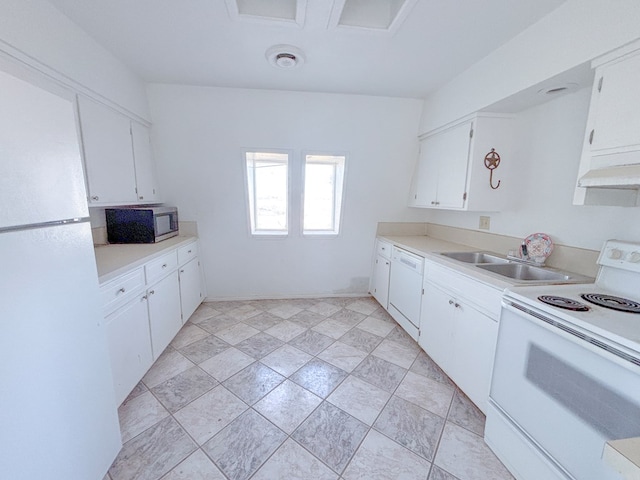 kitchen with white appliances, white cabinets, a sink, and light countertops