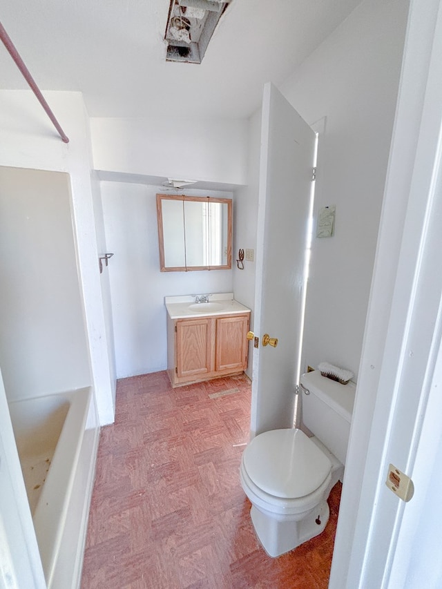 full bath featuring a washtub, vanity, and toilet