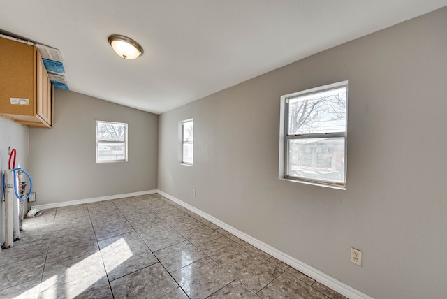 unfurnished room featuring vaulted ceiling