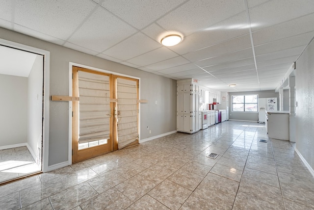 spare room with light tile patterned floors and a paneled ceiling