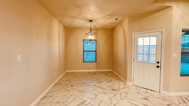 doorway to outside with an inviting chandelier