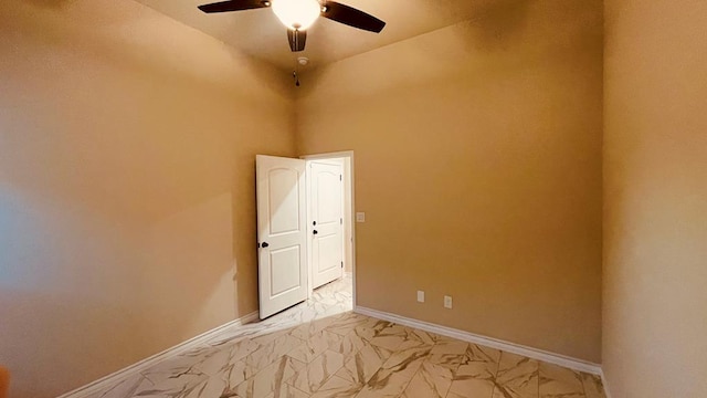 empty room with ceiling fan and a high ceiling