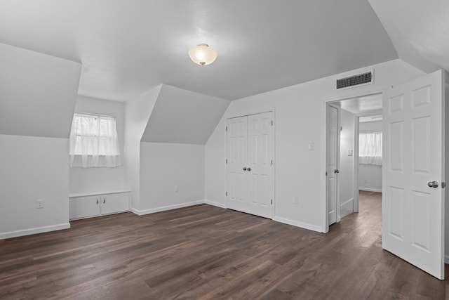 additional living space with dark hardwood / wood-style floors and vaulted ceiling