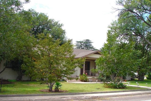 obstructed view of property with covered porch and a front yard