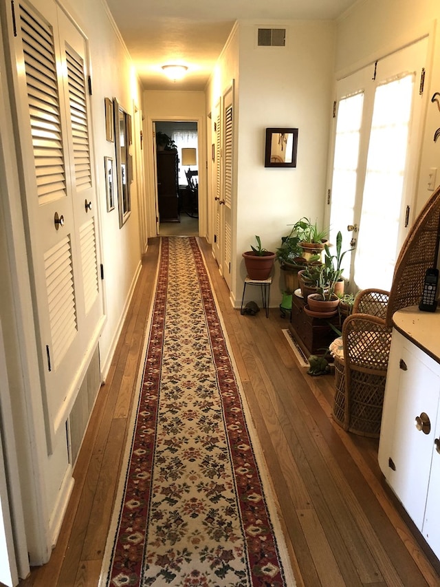 hallway with crown molding and dark hardwood / wood-style flooring