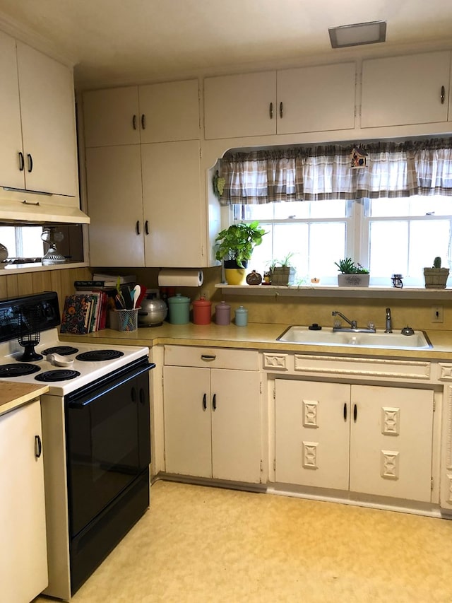 kitchen featuring white cabinetry, electric stove, and sink