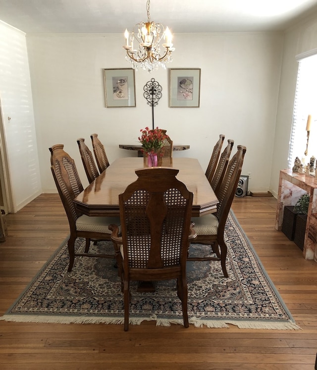 dining space with wood-type flooring and a notable chandelier