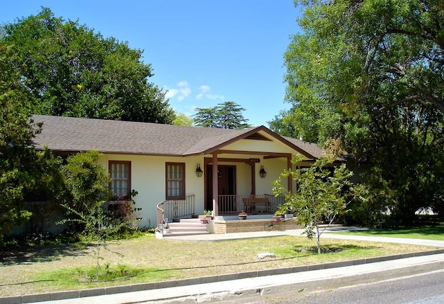 view of front of property with covered porch and a front lawn