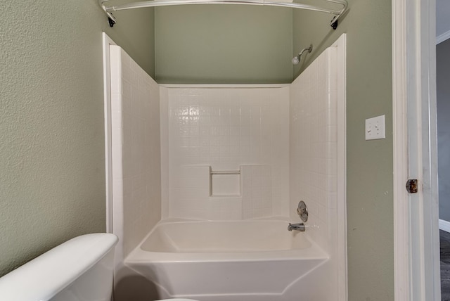 bathroom with bathtub / shower combination and toilet