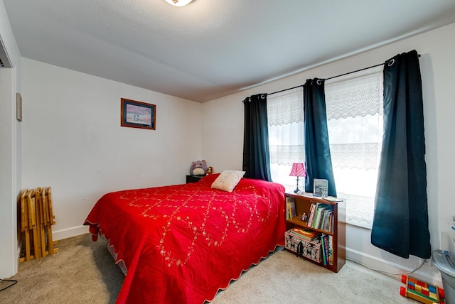 carpeted bedroom featuring radiator heating unit and a textured ceiling