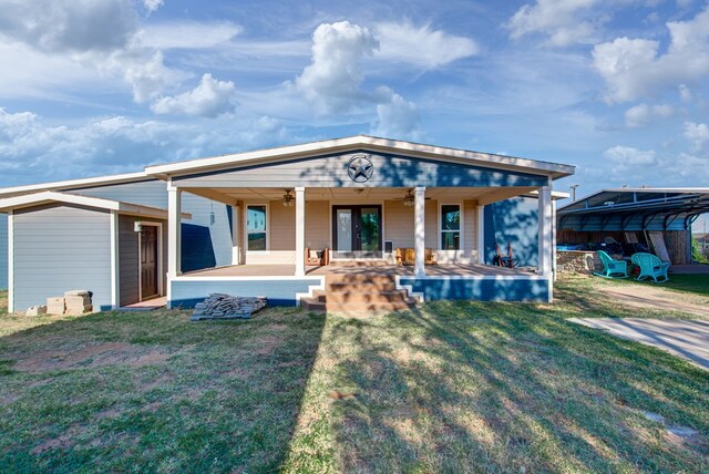 back of property featuring a lawn and ceiling fan