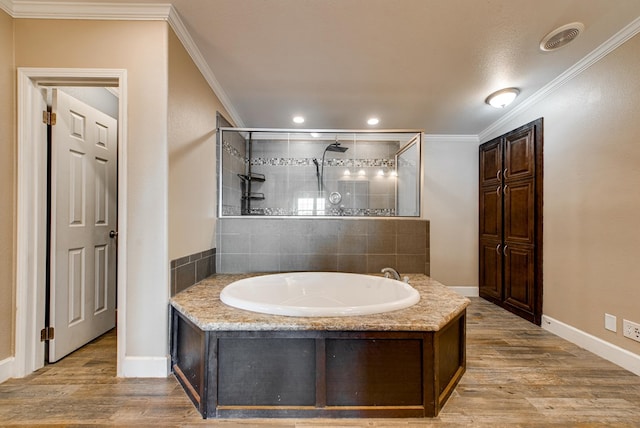 bathroom with wood-type flooring, separate shower and tub, and ornamental molding