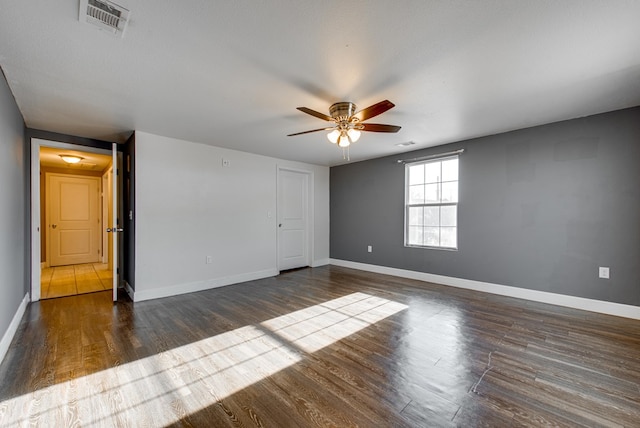 empty room featuring a textured ceiling, dark hardwood / wood-style floors, and ceiling fan