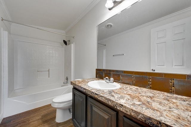 full bathroom featuring vanity,  shower combination, hardwood / wood-style flooring, toilet, and ornamental molding