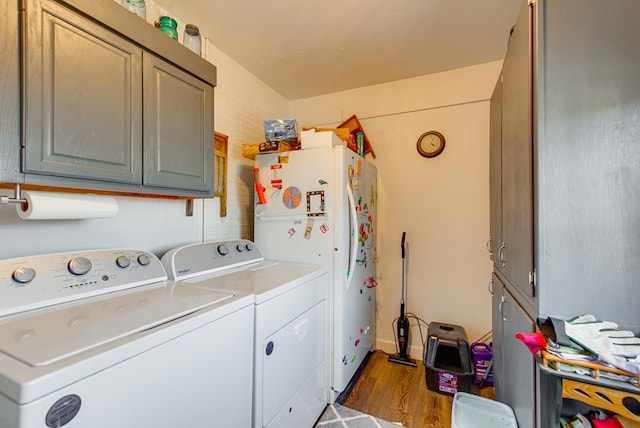 laundry area with washer and dryer, cabinets, and dark hardwood / wood-style floors