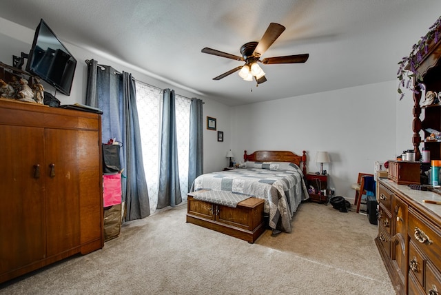 carpeted bedroom with ceiling fan and a textured ceiling