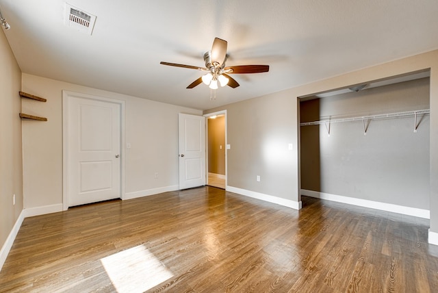 unfurnished bedroom with hardwood / wood-style floors, ceiling fan, and a closet