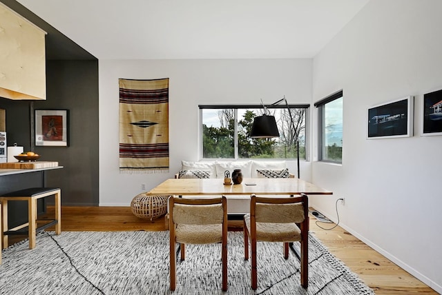 dining area featuring breakfast area, light wood-style flooring, and baseboards