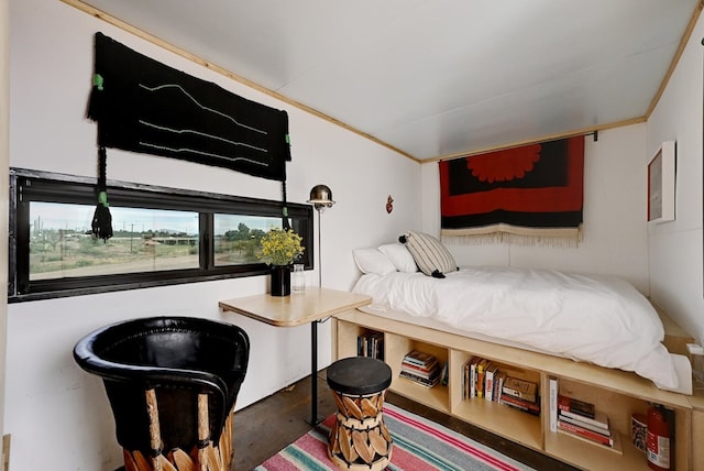 bedroom featuring ornamental molding and wood finished floors