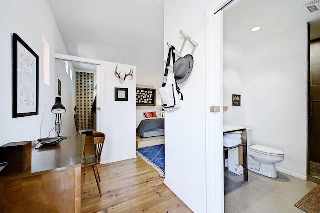 corridor featuring baseboards, visible vents, and wood finished floors