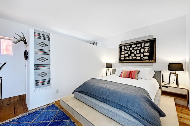 bedroom featuring wood finished floors and visible vents