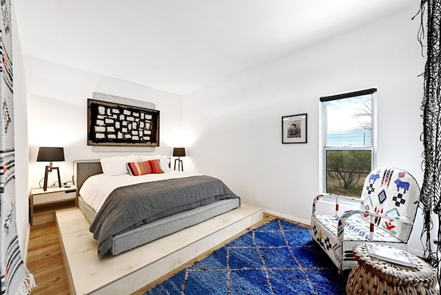 bedroom with baseboards and wood finished floors