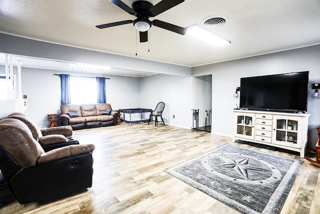 living area with a ceiling fan, wood finished floors, and visible vents