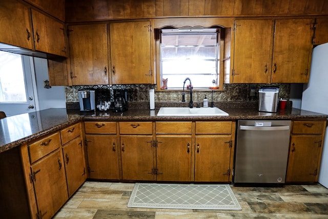 kitchen featuring stainless steel dishwasher, decorative backsplash, brown cabinets, and a sink