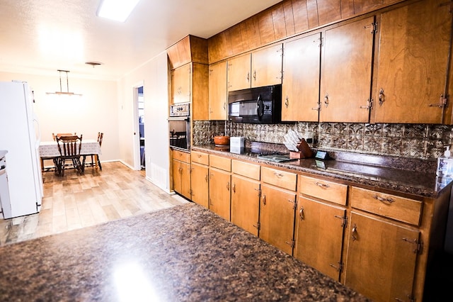 kitchen with black appliances, dark countertops, backsplash, light wood finished floors, and baseboards