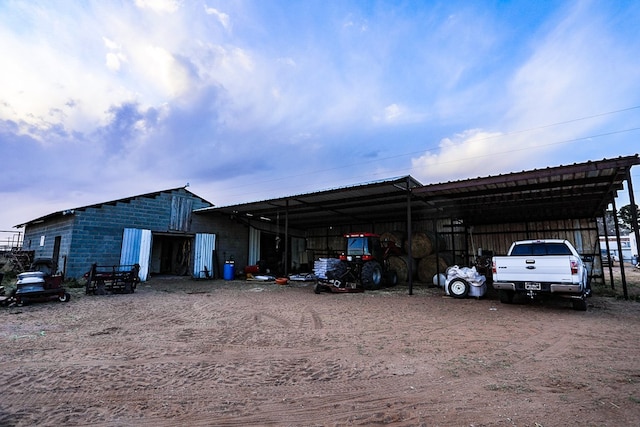 view of parking featuring a carport, an outbuilding, and driveway