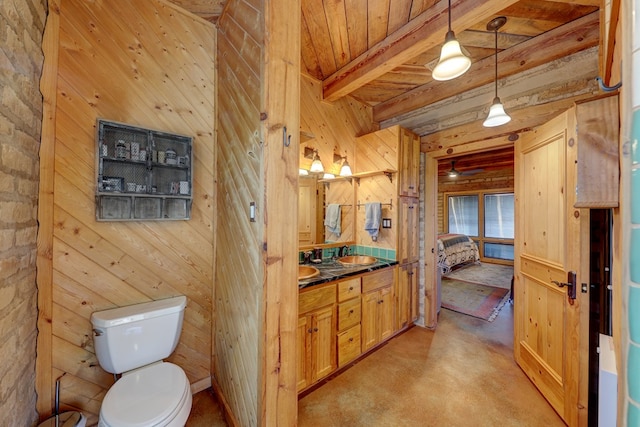 bathroom featuring wooden ceiling, beamed ceiling, toilet, wooden walls, and vanity