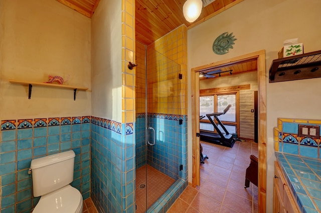 bathroom featuring tile patterned flooring, toilet, a shower with shower door, and wood ceiling