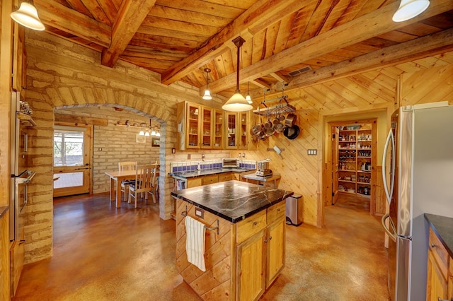 kitchen featuring appliances with stainless steel finishes, a center island, decorative light fixtures, and wooden ceiling