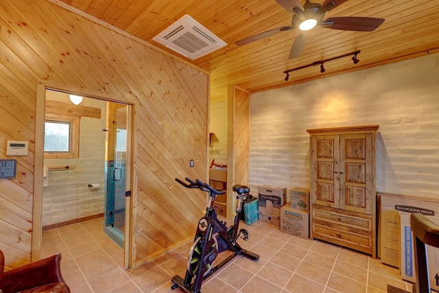 exercise area featuring ceiling fan, wood walls, and wood ceiling