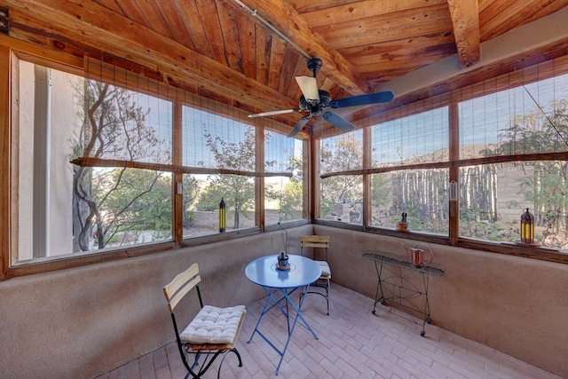 unfurnished sunroom with beamed ceiling, ceiling fan, and wood ceiling