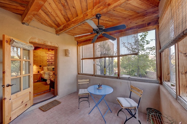 sunroom / solarium with beam ceiling, ceiling fan, and wood ceiling