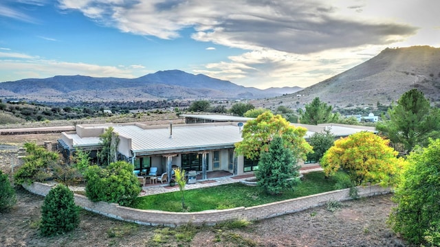 back of house with a mountain view and a patio area