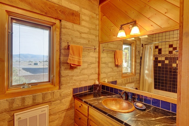 bathroom featuring heating unit, plenty of natural light, vanity, and walk in shower